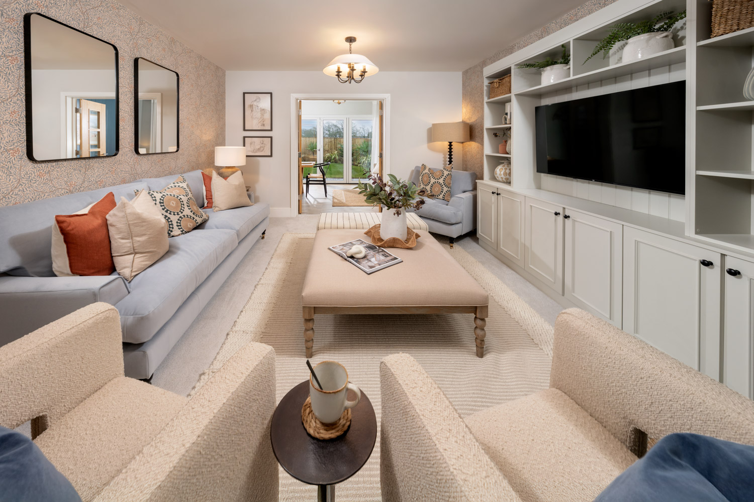Living room with cream chairs and carpet and grey sofa with patio doors to the rear