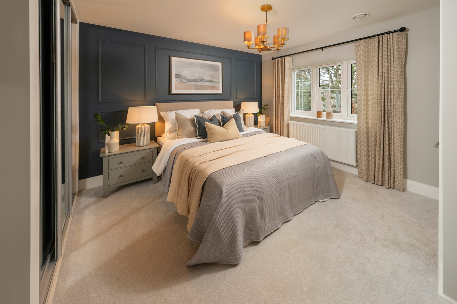 blue and cream coloured bedroom with made up bed and window to the rear